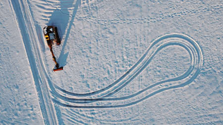 Aerial shot with drone of excavator in winter in snow