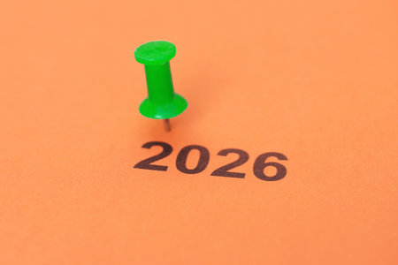 A thumbtack and a sheet of paper with the year 2026 written on it