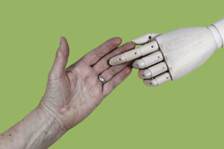 Elderly care in the future. A robotic hand and a human hand. Robot and human touch each other