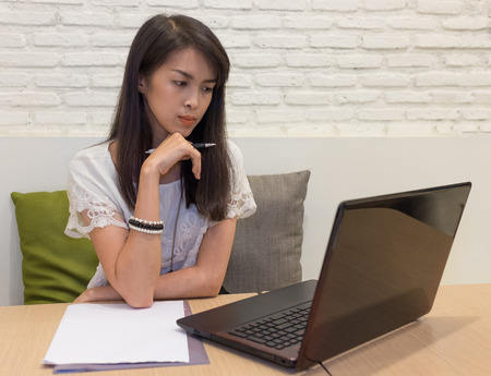 selective focus on thai adult women working with labtop on a desk at homeの写真素材