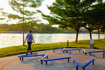 soft focus on one adult woman exercise outdoor  alone with balance bench in evening at parkの写真素材
