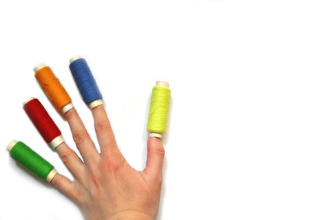 many threads of different bright colors hold in a hand on fingers