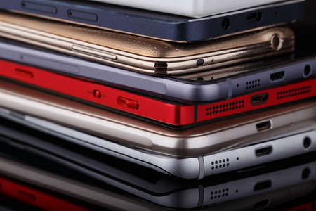 Heap of electronical devices close up - smartphones on black backgroundの写真素材