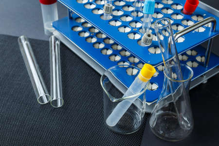 Laboratory glass and color test blood tubes on stand. Medical instruments.