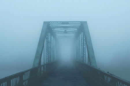 Fog is covering an old metal bridge creating a mysterious and moody atmosphereの素材