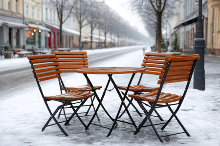 Snow falling on outdoor seating of a closed restaurant on a cold winter dayの素材