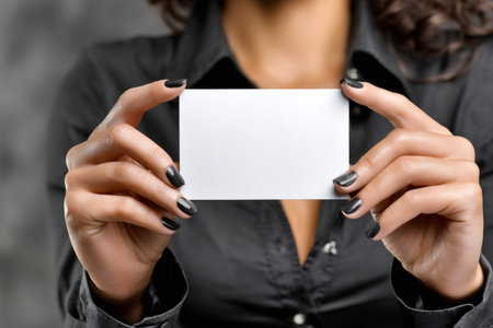 Woman's hands displaying an empty white business card, offering a customizable marketing mockupの素材
