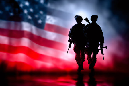 Silhouettes of two armed soldiers walking against a waving American flagの素材