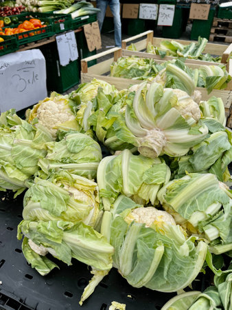Beautiful cauliflower with green leaves on the table