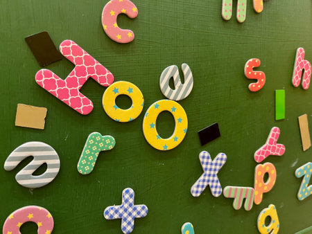 Male kid playing with alphabet letters board on table top view. Intellectual game preschool.
