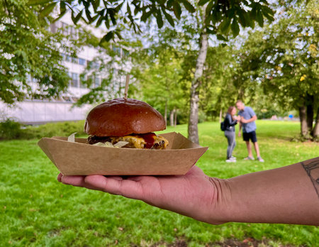 Hamburger at outdoor street food market festival in a Czechs city Teplice. Mans handの写真素材