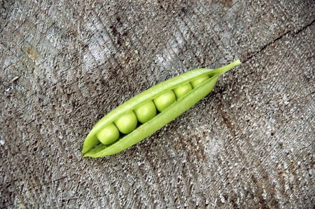 One pea pod on the wooden surfaceの写真素材