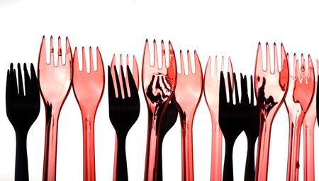 non-transparent  and semi-transparent red plastic forks against back lightの写真素材