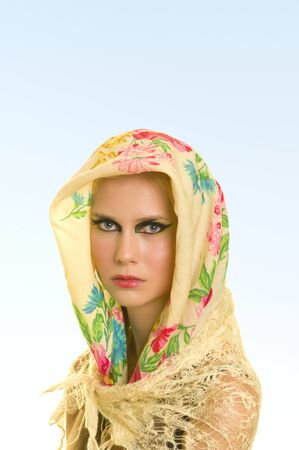 young woman in shawl against light blue backgroundの写真素材