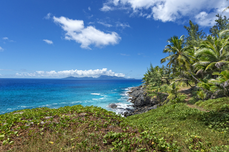 blue ocean, rocky shore, pathway on the edge of tropical forest  Silhouette island, Seychelles の写真素材