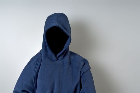 A blue hoodie with nothing but a dark shadow in place of a face against a white wall with copy-space.の写真素材