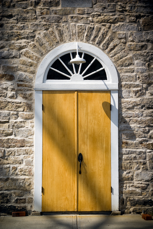 An arched doorway set in an old, vintage stone wall  Architectural detail of stonework in the Victorian High Gothic style の写真素材