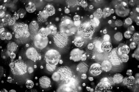 Macro close-up abstract black and white shot of many air-bubbles suspended in a blown glass sphere,