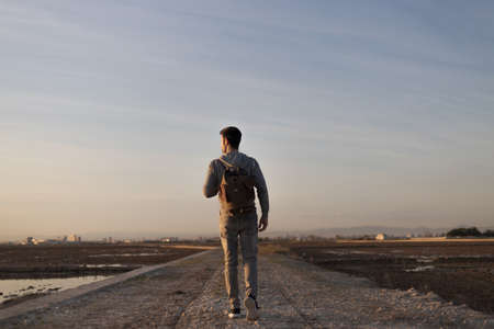 man with travel backpack and a sunsetの写真素材