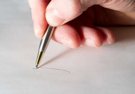 Close up photograph of hand writing with penの写真素材