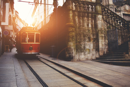 Traditional vintage tram makes its way across central streets in old city in sunny morning, public transport on metallic rails standing near architectural monument, electrical streetcar in urban sceneのeditorial素材