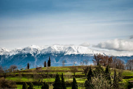 Green lawns and snowy mountains in Italyの写真素材