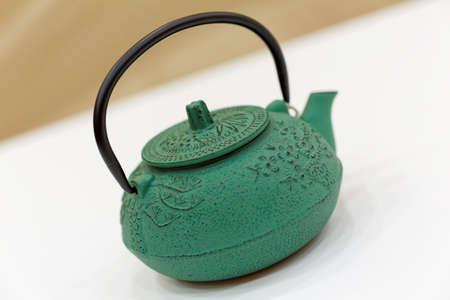 chinese iron green teapot on the white tableの写真素材