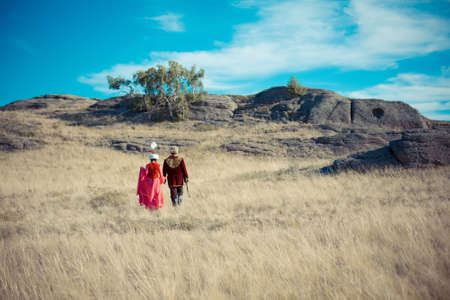 man and woman in kazakh national costume in the steppeの写真素材
