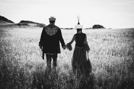 Couple in medieval clothes at sunset. Black and white photo.Kazakh woman and man in national costumesの写真素材