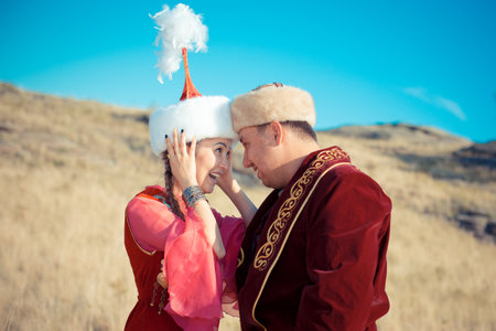 Young couple in medieval clothes on the background of the blue sky. Kazakh woman and man in national costumesの写真素材