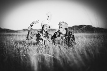 Elderly man and woman in the steppe. Kazakh woman and man in national costumes