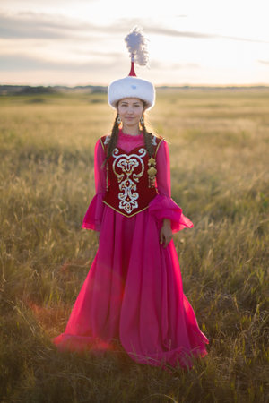 Beautiful young woman in a medieval dress in the field at sunset Kazakh woman and man in national...