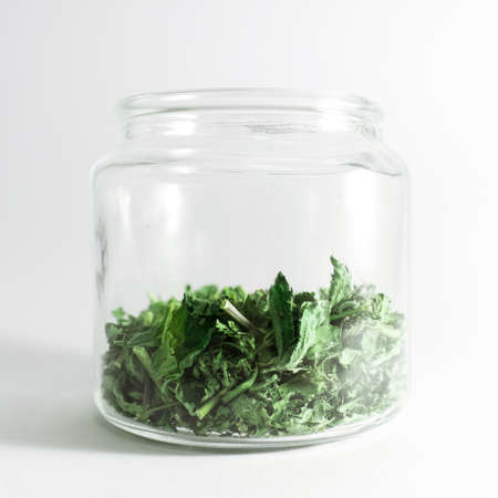 Dry melissa and mint tea in the jar isolated on white background. Homemade and healthyの写真素材