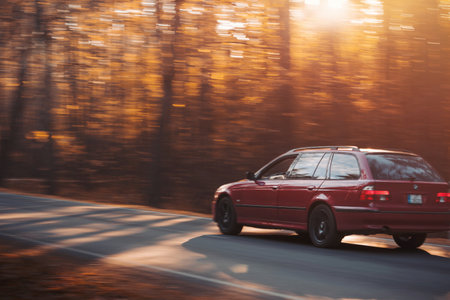 Riga, Latvia - 10 October 2021. Red car is driving on the street at high speed on a sunny autumn...