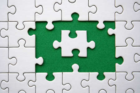 One white jigsaw piece on a jigsaws frameの写真素材