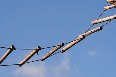 Wooden rope ladder on a blue sky backgroundの写真素材
