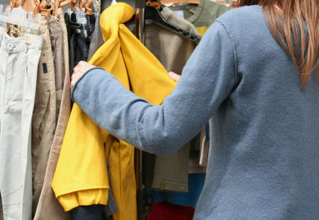 Young woman looking at clothes in a shopの写真素材