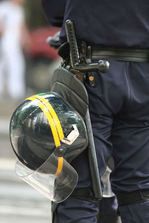 Helmet and truncheon on a police officer in the street