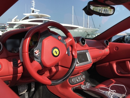 Marbella, Spain - August 10, 2018: Part of a red Ferrari parked inside the famous Puerto Banus. Luxury port where you can take a walk, have a drink and see large and luxurious yachtsのeditorial素材