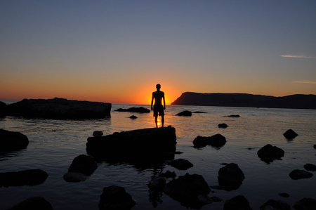 trained male body silhouette on the beach at sunset On the background of the seaの写真素材