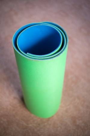 Mat for yoga green and blue rolled upの写真素材