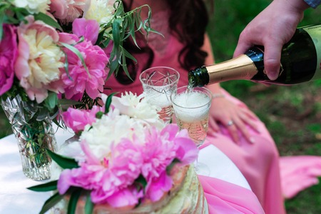 Pouring champagne into a glass on some festive event or weddingの写真素材