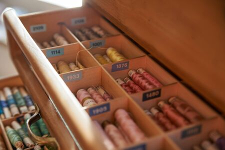 Drawer with different colored threads in it is the windfall for every housewife. Top view.の写真素材