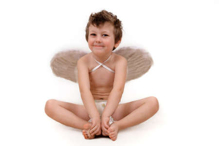 Baby with angel wings sitting laughing holding his feetの写真素材