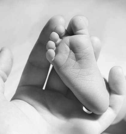 Baby feet on mother handv