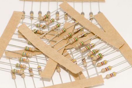 Assortment of Carbon Resistors still in cardboard strips in a pile on white backgroundの写真素材