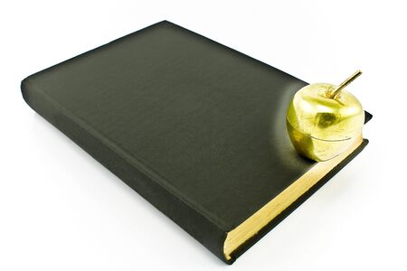 Golden apple on old book isolated on whiteの写真素材
