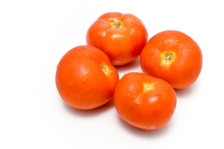 Four fresh tomatoes isolated on whiteの写真素材