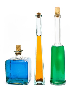 Three antique bottles with colorful liquids isolated on a whiteの写真素材