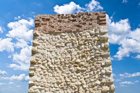 Stone monolith over blue sky with white cloudsの写真素材